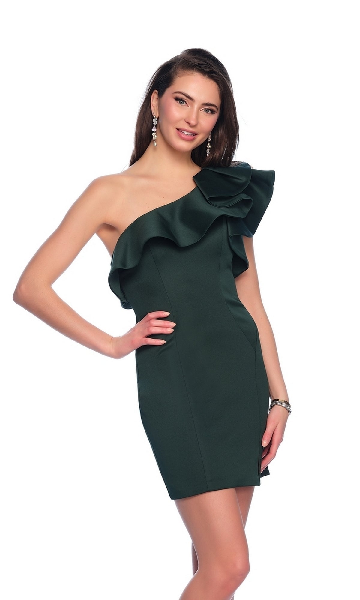 A woman wears the One-Shoulder Short Ruffled Homecoming Dress 10933, featuring a dark green color and asymmetrical neckline, posing with one hand on her hip against a white background.